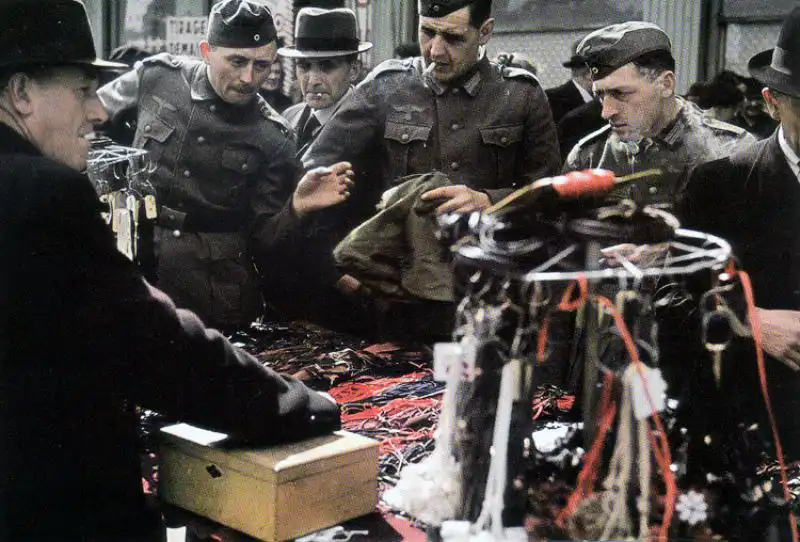 German Wehrmacht soldiers bargaining with a street vendor in occupied Paris, 1942 color photograph