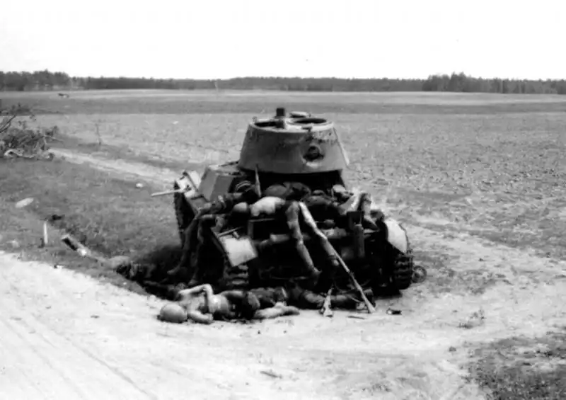 Destroyed Soviet XT-133 flamethrower tank surrounded by fallen Red Army soldiers during the summer of 1941 on the Eastern Front