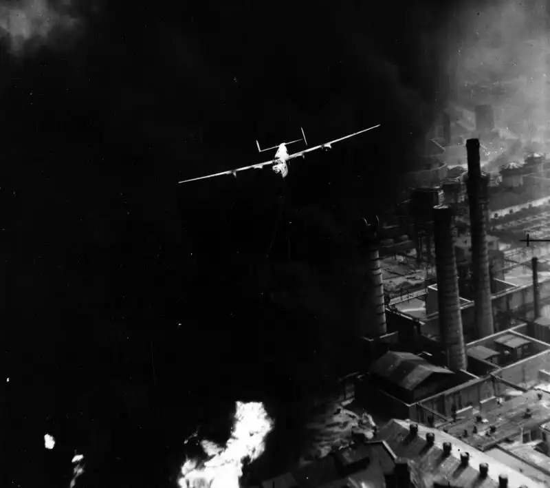 B-24D Liberator bomber flying extremely low over burning oil refinery stacks in Ploesti Romania 1943.