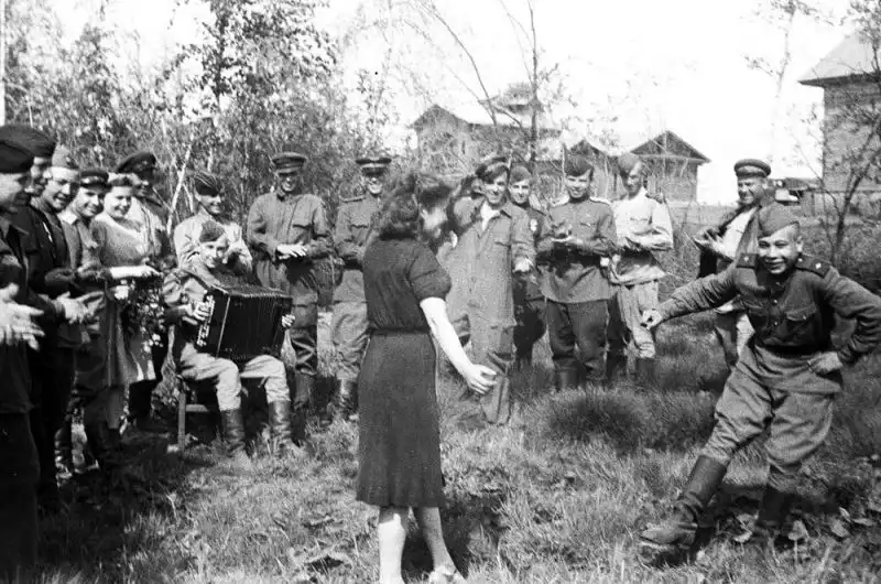 Soviet ferry pilots dancing with local women during a rest stop in Yakutsk while transporting Lend-Lease aircraft along the ALSIB route in 1943.