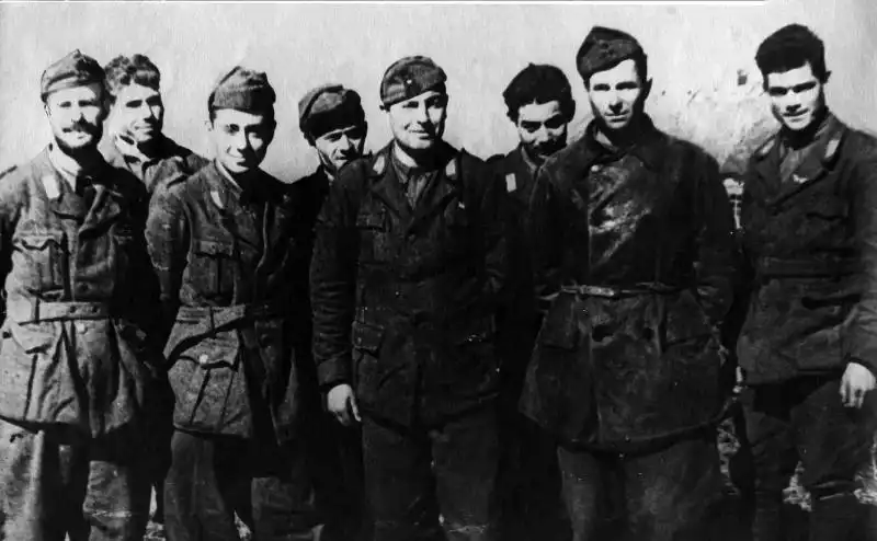 Group of Italian prisoners of war smiling in a Soviet transit camp during spring 1943.
