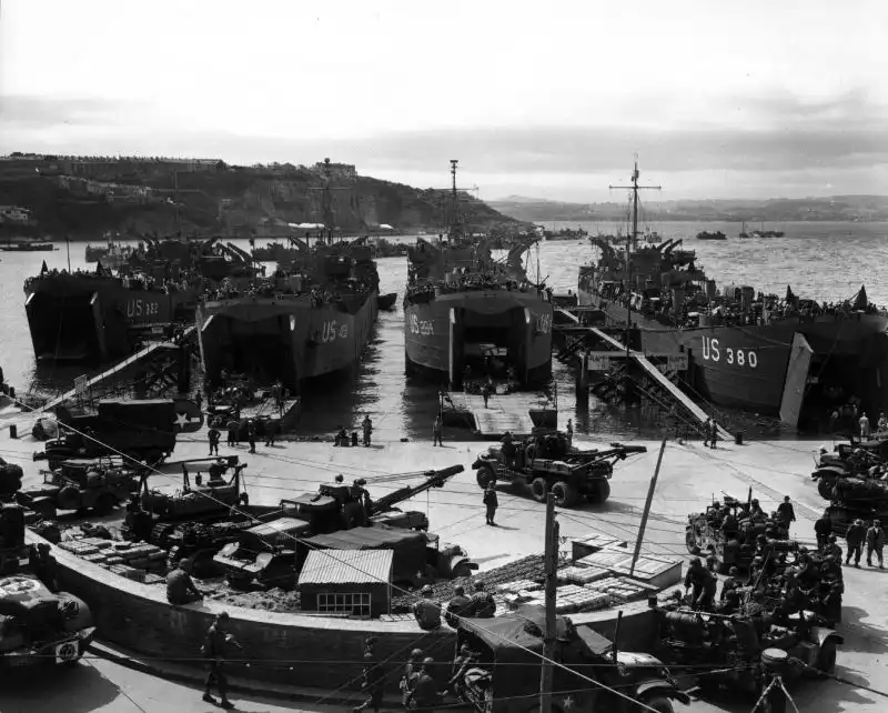 Allied vehicles being loaded for the Normandy invasion, including M1A1 wreckers and Caterpillar tractors at Brixham Port
