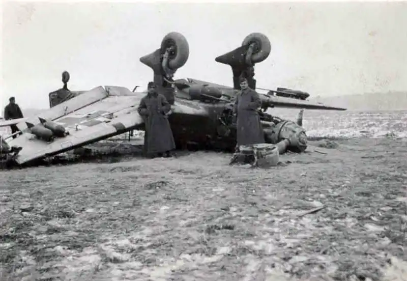 Overturned Junkers Ju 87B-2 Stuka dive bomber with bombs still attached after a takeoff accident at a German airfield.