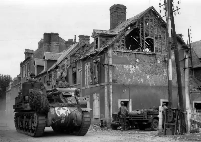 An M7 Priest 105mm self-propelled gun from the 14th Field Artillery Battalion, 2nd Armored Division “Hell on Wheels,” moves through the ruins of Cherbourg during the Allied push to capture the strategic port