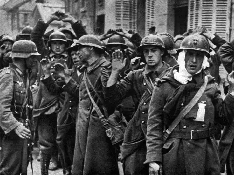 French prisoners of war guarded by a German Wehrmacht soldier after the Fall of France in 1940.