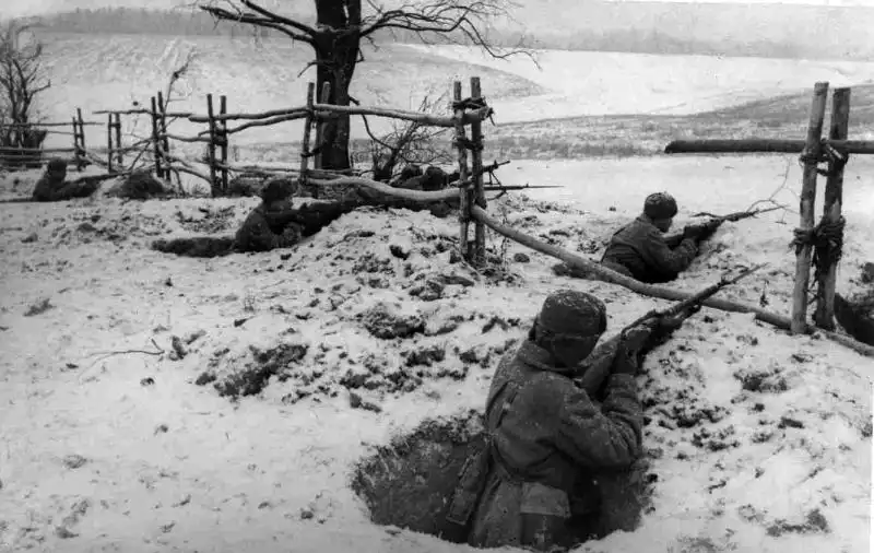 Soviet infantrymen with Mosin–Nagant rifles occupy snow-covered defensive positions during the Battle of Moscow counteroffensive, December 1941.