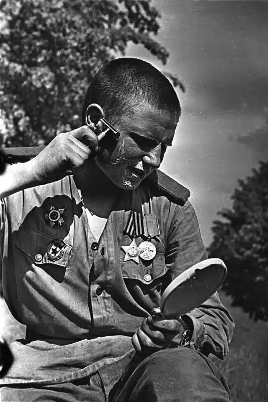 Guards Private Pavel Karpov of the Red Army shaving with an American Gillette safety razor in Germany after the end of World War II in Europe, June 1945