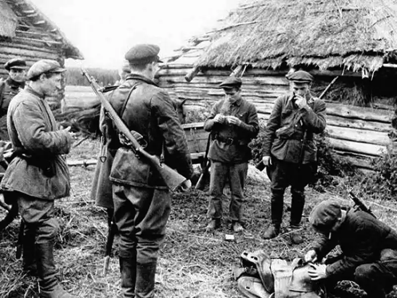Soviet partisans equipped with British Lee-Enfield SMLE rifles and cavalry sabers in a rural village, Leningrad region 1942.