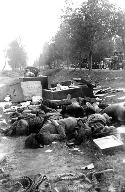 Dead Soviet civilians and soldiers lie beside a destroyed GAZ-AA truck after a German attack on a road convoy during the invasion of the USSR in 1941