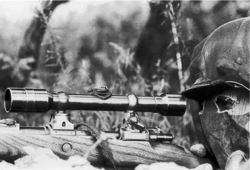 German sniper wearing a camouflage face mask with Kar98k rifle and scope
