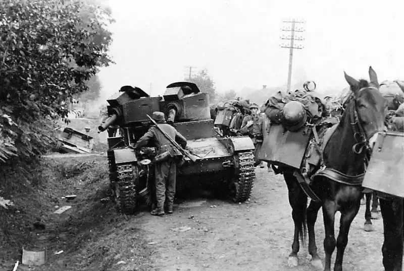 German mountain troops with pack horses marching along a dirt road past a disabled Polish two-turret Vickers Mk.E tank armed with a 37mm gun and wz.30 machine gun in September 1939.