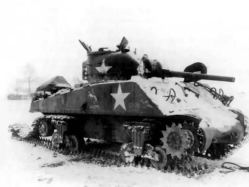 Disabled US M4A3 Sherman tank named GALLERO with fighting rooster insignia in snow during the Battle of the Bulge 1944.