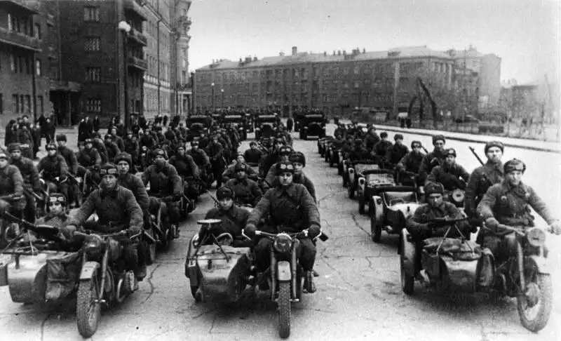 Soviet motorcycle column with M-72s armed with DP-27s and Mosin rifles, preparing for deployment to the Eastern Front. Lead vehicle: FAI-M; rearguard: GAZ-AAA.