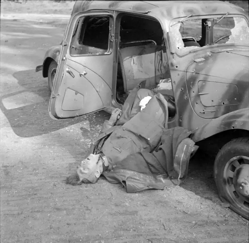 Black and white historical photo showing a destroyed Citroen staff car on a road in the Netherlands following the ambush of General Friedrich Kussin in September 1944.