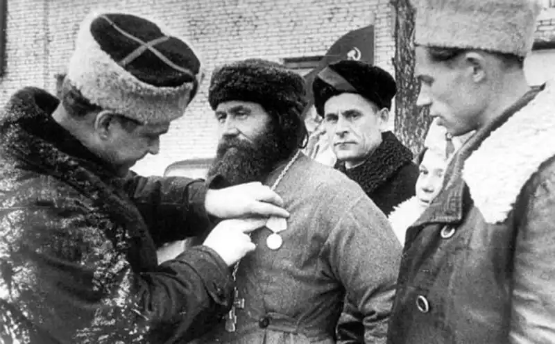 Partisan brigade commander Konstantin Karitsky attaching medal to Orthodox priest Fyodor Puzanov in Leningrad region 1944.
