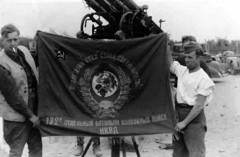 Captured banner of the Soviet 132nd NKVD Battalion held by German soldiers in Brest Fortress, 1941.