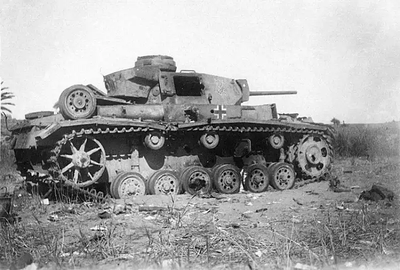 Destroyed German Pz.Kpfw. III tank of Rommel’s Afrika Korps, likely from the 15th or 21st Panzer Division, knocked out during fighting in the North African campaign