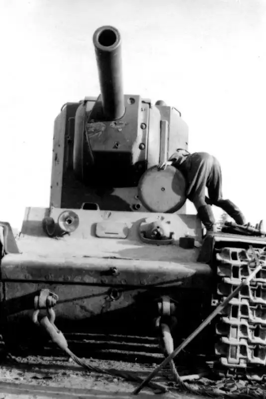 Captured Soviet KV-2 heavy tank, showing visible battle damage, with a German soldier inspecting it near Ostrov, July 5, 1941.