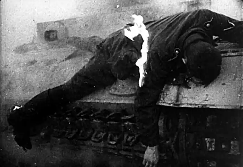 Black and white archival film still showing a knocked-out German Panzer III medium tank on the battlefield during the summer of 1943.