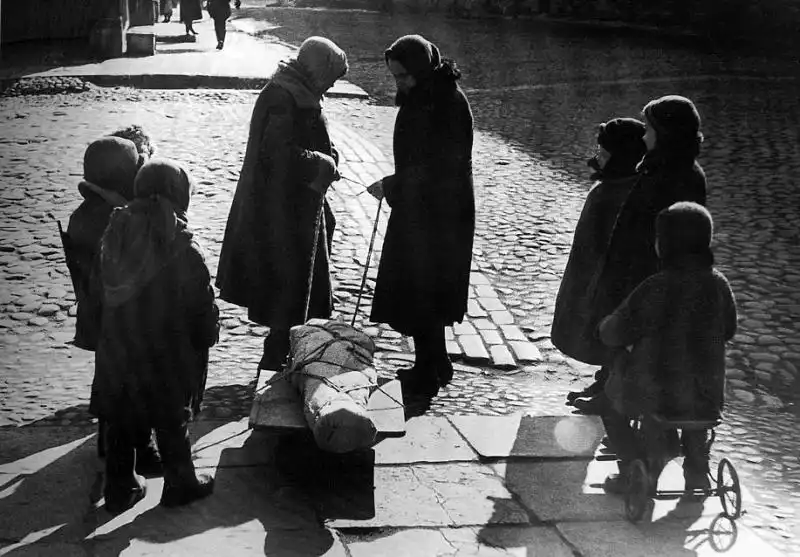 Children in besieged Leningrad mourn a peer who died from starvation, deprivation, or artillery bombardment, spring 1942