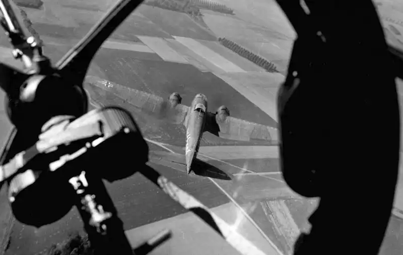 German Heinkel He 111 twin-engine bomber flying in formation, photographed from another Luftwaffe aircraft with MG 15 machine gun visible