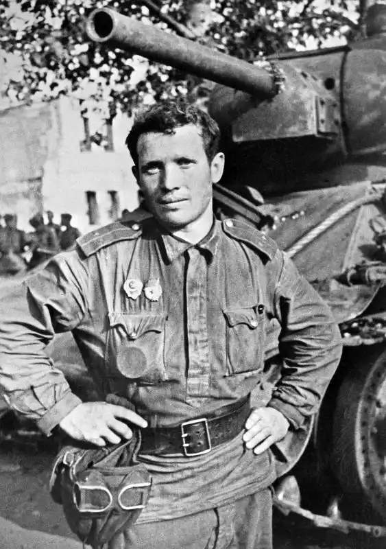 Guards Lieutenant Nikolai Pavlovich Borozdnov standing beside his T-34 medium tank during the Soviet summer offensive near Orel, USSR, 1943.