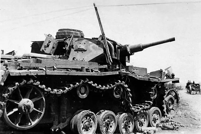 Disabled German Panzer III Ausf. J tank with broken tracks and damaged road wheels on a dirt road near Sevastopol in summer 1942.