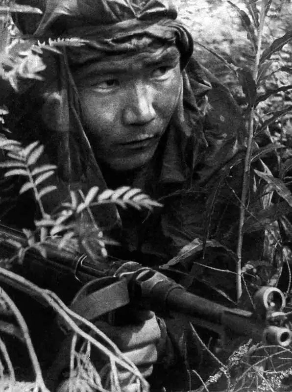 A Soviet frontline reconnaissance scout in a camouflage suit holding a captured German MP 40 submachine gun.