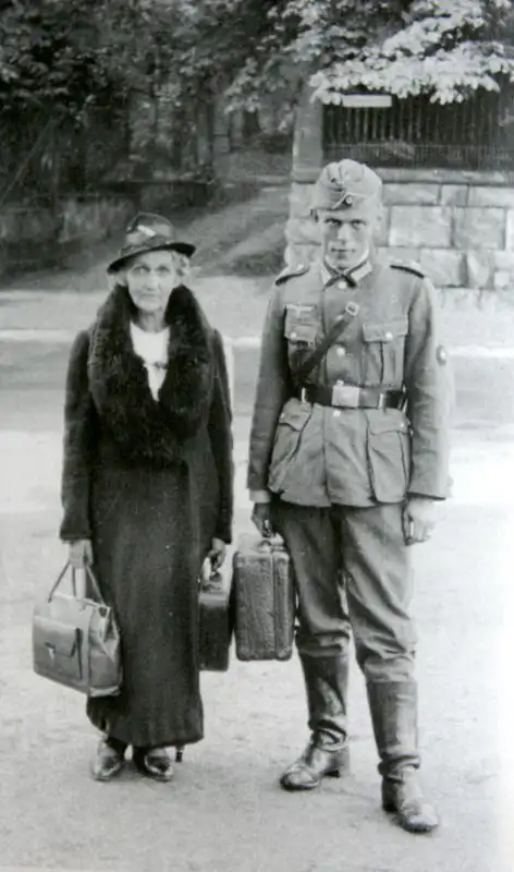 German Officer Candidate with shoulder strap and suitcase standing next to his mother in Leipzig September 1940.