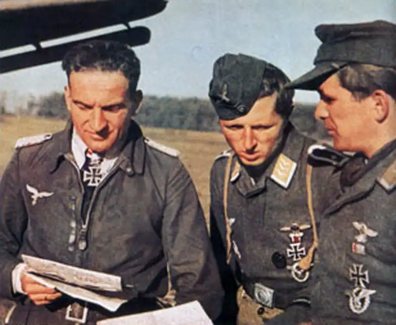 Luftwaffe pilot Hans-Ulrich Rudel wearing Knight's Cross discussing flight plans with StG 2 Stuka pilots on the Eastern Front.
