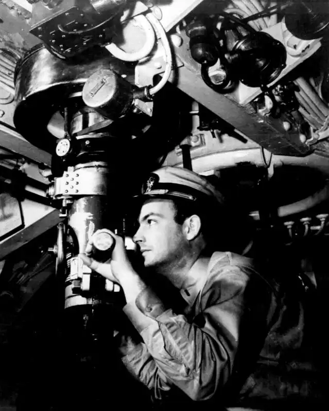 U.S. submarine officer Raymond Alexander looking through a periscope inside a WWII submarine, Pacific Ocean 1942