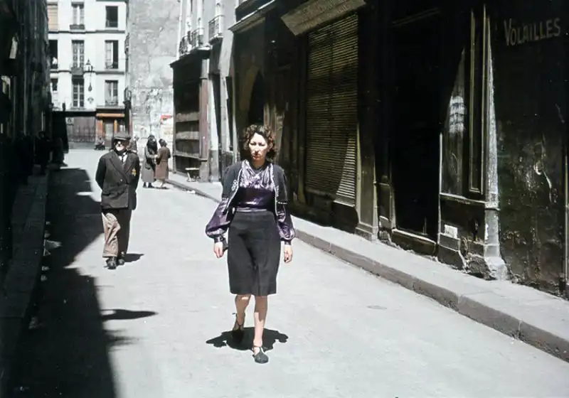 Rue des Rosiers in occupied Paris with a man wearing a yellow Star of David visible in the background, 1942 color photograph