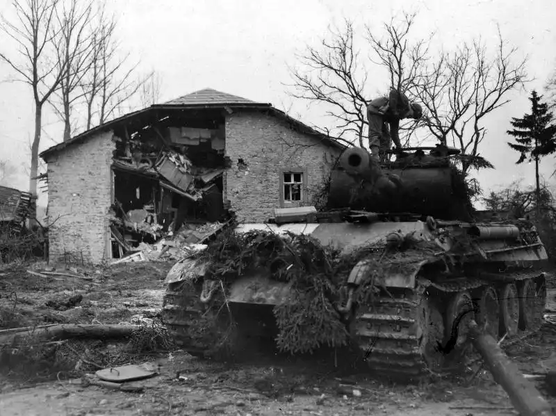 American soldier inspecting a knocked-out German Panther tank of 2nd SS Panzer Division Das Reich in Grandmenil, Belgium 1944.