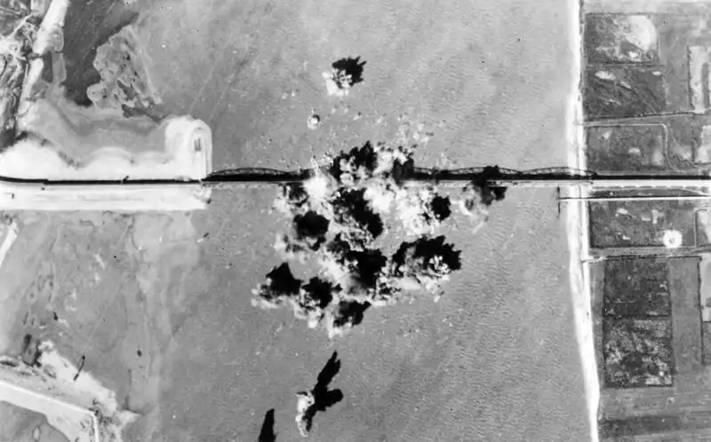 Aerial view of bomb detonations directly striking the Prince Peter II bridge over the Danube River in Belgrade September 1944.