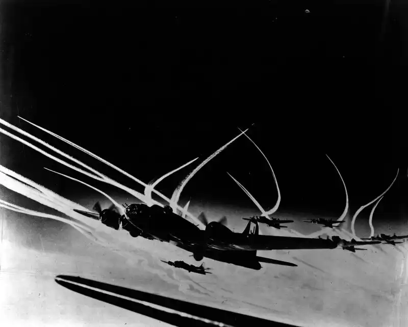 B-17 Flying Fortress bombers of the 390th Bomb Group flying in formation over Germany with Allied fighter contrails visible in the background, December 1943.