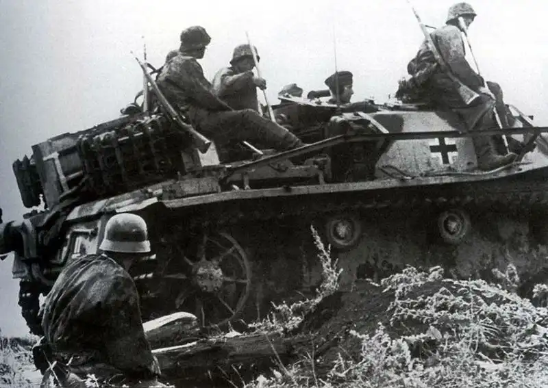 Black and white WWII photo of German SS pioneers sitting on top of an early production StuG III Ausf. G assault gun during the Battle of Kursk in July 1943.