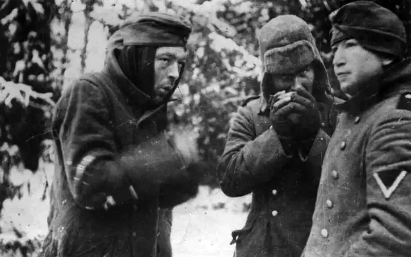 Frostbitten German prisoners of war shivering in thin coats near Moscow in winter 1941.