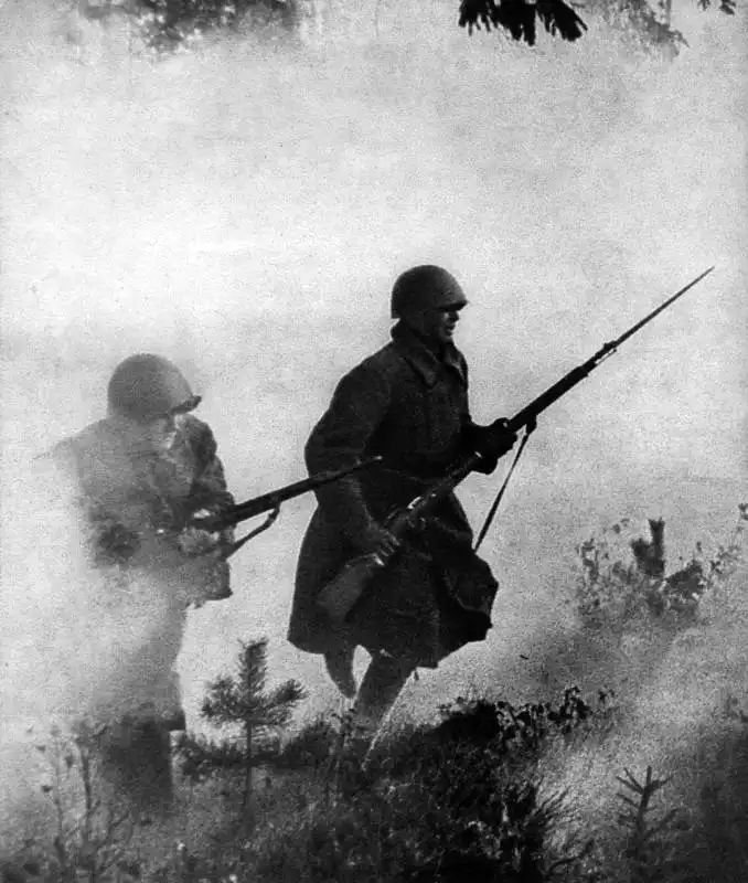 Two Soviet Red Army infantrymen push forward under foggy conditions during the Battle of Leningrad