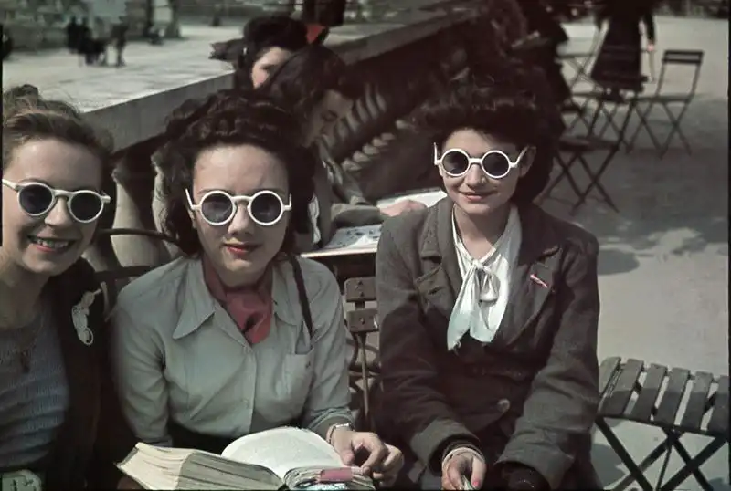 Fashionable young Parisian women posing in Luxembourg Gardens during German occupation, May 1942 color photo