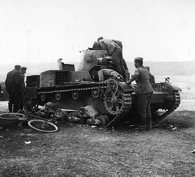 Black and white historical photo of German soldiers with bicycles examining an abandoned twin-turret Polish Vickers 6-ton tank in Poland in 1939.
