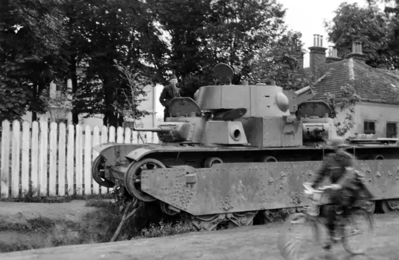 Abandoned Soviet T-35 multi-turret heavy tank inspected by German soldiers on Lvivska Street in Grodek, Ukraine, 1941