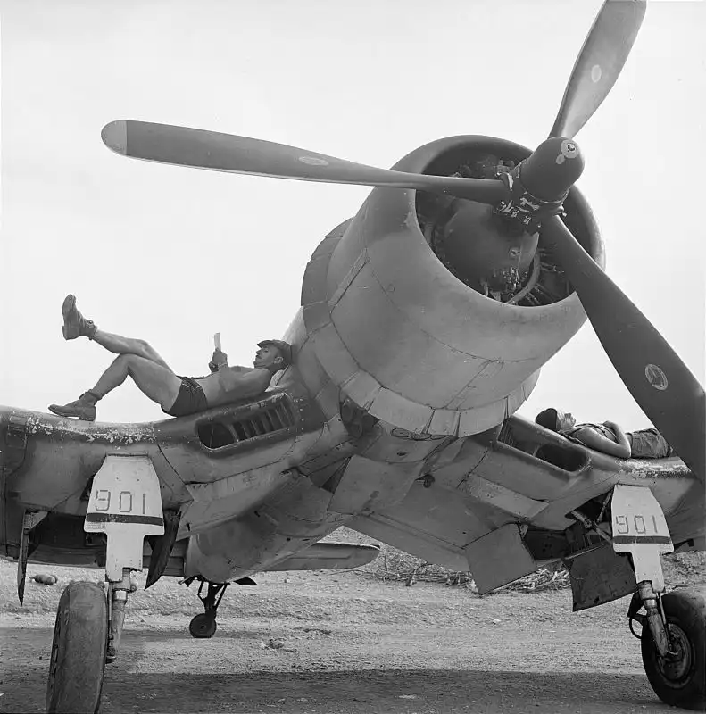 U.S. Marine Corps aviation mechanics resting on the wings of a Vought F4U Corsair at Bougainville Island, April 1944.