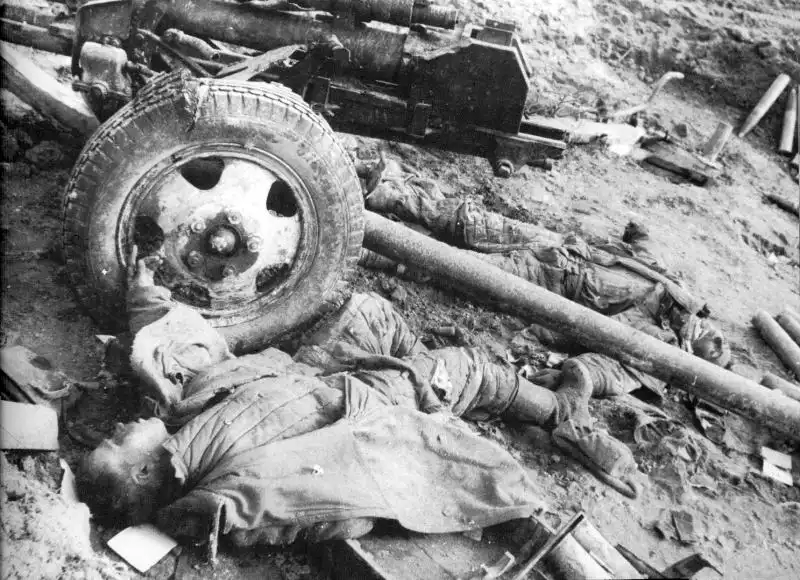A destroyed Soviet 76 mm ZiS-3 divisional gun and fallen Red Army artillerymen in winter uniforms on a prepared firing position in February 1943.