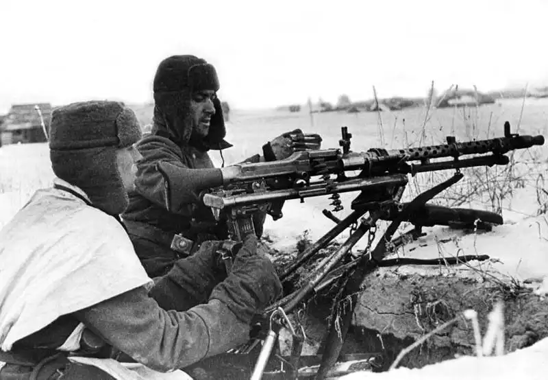 German soldiers with an MG-34 machine gun in winter conditions on the Eastern Front during 1942-1943. This photograph shows the soldiers wearing ushanka hats