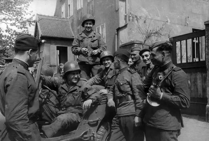 Soviet and American soldiers shake hands on the Elbe River