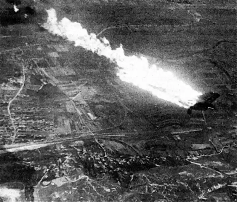 Black and white aerial photo showing a German Heinkel He 111 bomber trailing a massive streak of fire and smoke as it falls over the terrain of Lvov, June 1941.