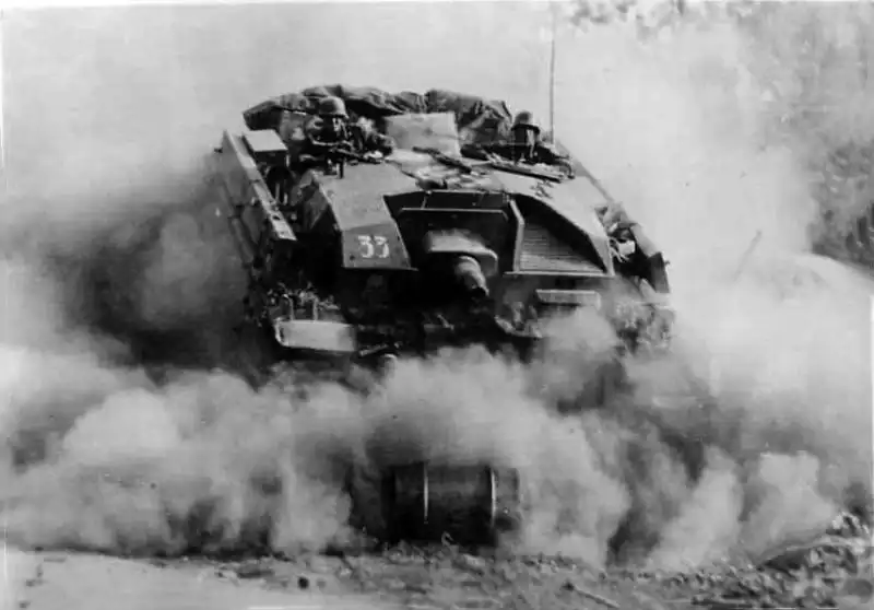 A German StuG III Ausf. B assault gun advancing at high speed through dust in Opochka during 1941.