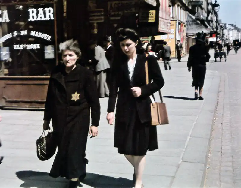 Elderly Jewish woman wearing a yellow Star of David walking in occupied Paris, 1941 color photograph