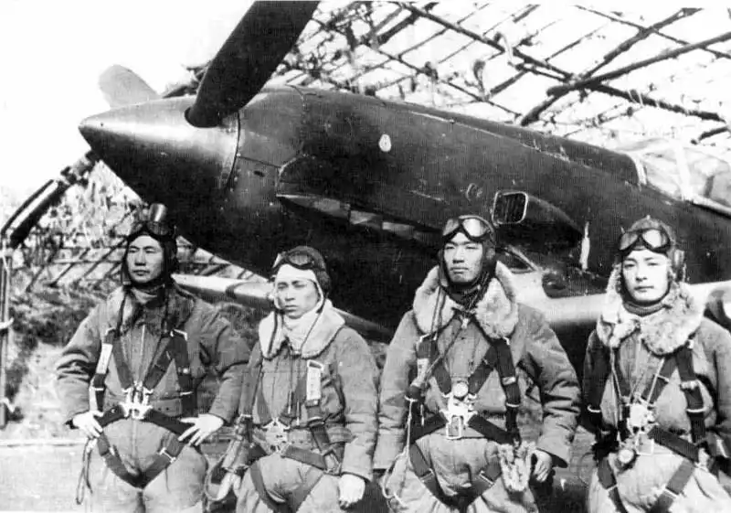 Four Japanese fighter pilots pose beside a Kawasaki Ki-61 Hien fighter aircraft before a combat mission defending Japan in 1945.