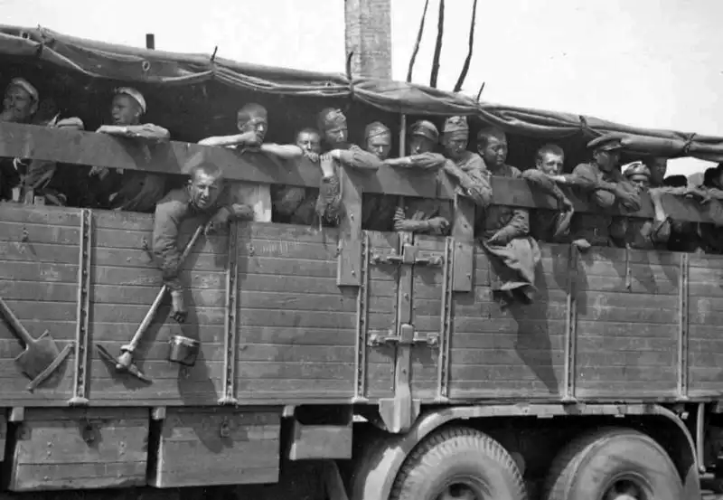Soviet prisoners of war transported in the cargo bed of a German heavy truck in Ukraine during autumn 1941.